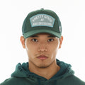 Cult's Mesh Trucker Hat "Good At Bad Decisions" In Bayberry